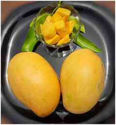 黄色的美味的芒果减少块碗漂亮的黑色的板夏天水果好健康