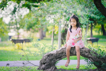 可爱的亚洲女孩娃娃坐着公园