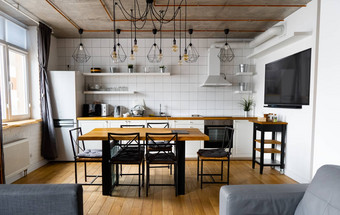 现代斯堪的那维亚堂食厨房室内设计大木表格椅子光木地板上明亮的白色墙家具电器挂光灯泡