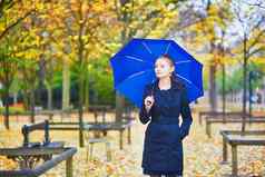年轻的女人蓝色的伞卢森堡花园巴黎秋天春天多雨的一天