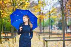 年轻的女人蓝色的伞卢森堡花园巴黎秋天春天多雨的一天