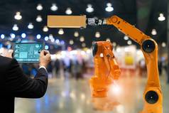 工程师触摸屏幕控制机器人生产工厂部分引擎制造业行业机器人机械手臂