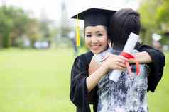 年轻的女研究生拥抱朋友毕业仪式