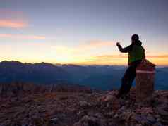 徒步旅行者需要自拍照片男人。坐奥地利德国边境石头高山山