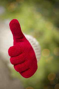 女人穿红色的连指手套持有拇指手标志