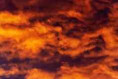 金云日落浮动紫罗兰色的紫色的雷云天空