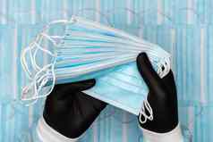 护士持有集团蓝色的外科手术医疗脸面具黑色的保护手套手概念检疫保护流感大流行爆发
