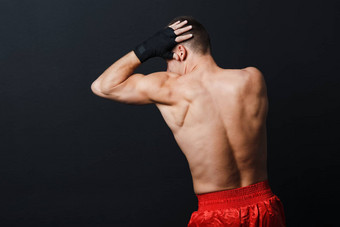 运动员<strong>泰拳泰国</strong>男人。拳击手的立场肘穿孔黑色的背景