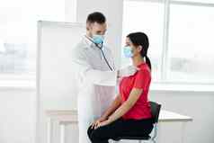 医生医疗面具站女人红色的t恤胸部检查呼吸肺科维德