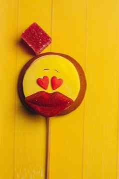 姜饼形式笑脸红色的嘴唇果酱甜点糖果黄色的背景