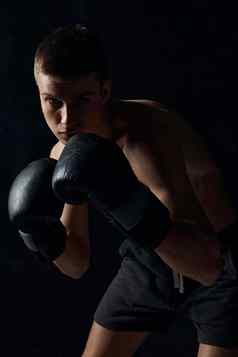 男人。拳击手套黑色的背景锻炼健美运动员健身
