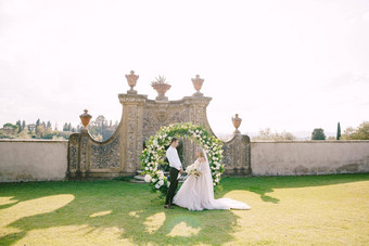 婚礼酒庄别墅托斯卡纳意大利婚礼夫妇轮婚礼拱装饰白色花绿色植物前面古老的意大利体系结构