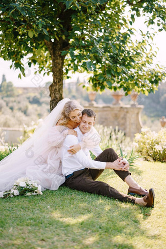 婚礼弗洛伦斯意大利villa-winery婚礼夫妇坐着草花园树新娘拥抱新郎