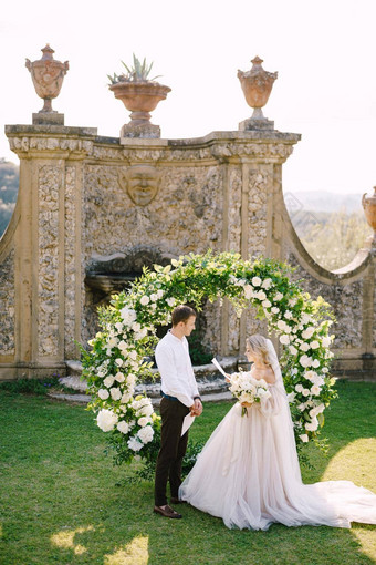 新娘读取婚礼誓言婚礼酒庄别墅托斯卡纳意大利轮婚礼拱装饰白色花绿色植物前面古老的意大利体系结构