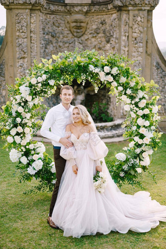 婚礼酒庄别墅托斯卡纳意大利婚礼夫妇轮婚礼拱装饰白色花绿色植物前面古老的意大利体系结构