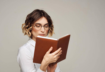 女人眼镜持有书手灰色的背景短发型模型