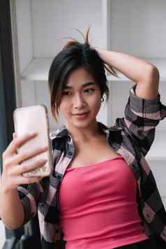 图像年轻的浅黑肤色的女人亚洲女人微笑采取自拍照片手机咖啡馆商店