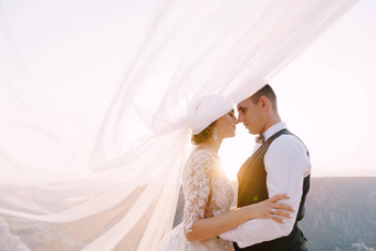 艺术目的地婚礼照片黑山共和国山狩猎婚礼夫妇拥抱前山日落新郎拥抱新娘腰面纱挥了挥手空气