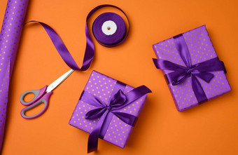 礼物盒子系紫色的丝绸丝带橙色背景前视图节日背景