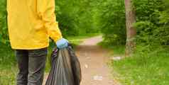 志愿者清洁垃圾森林人护理地球污染塑料垃圾工人手持有垃圾袋绿色横幅志愿者手选择塑料垃圾草公园生态友好的