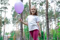 漂亮的女孩粉红色的紧身裤白色t恤紫色的热空气气球公园霍利迪聚会，派对生日庆祝活动快乐孩子们