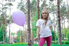 漂亮的女孩粉红色的紧身裤白色t恤紫色的热空气气球公园霍利迪聚会，派对生日庆祝活动快乐孩子们