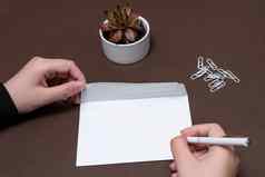 女人手持有空白笔记写作分机更新的想法夫人棕榈显示信封折叠发送信帖子地址