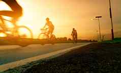 模糊照片体育男人。骑自行车速度运动路晚上日落天空夏天户外锻炼健康的快乐生活骑自行车的人骑山自行车自行车车道团队