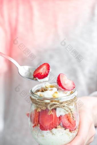 女手女人吃健康的早餐燕麦片格兰诺拉麦片希腊酸奶坚果草莓牛奶什锦早餐罐子光背景健身重量损失饮食概念排毒菜单