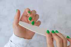 修剪整齐的女手时尚的绿色指甲时尚的现代设计修指甲过来这里指甲皮肤护理美治疗指甲护理时尚的颜色修指甲工具