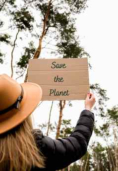 女手持有纸板文本保存地球在户外自然背景抗议者积极分子