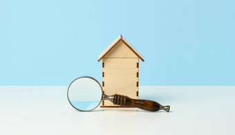 放大镜木房子蓝色的背景真正的房地产租赁购买出售概念房地产经纪人服务建筑修复维护