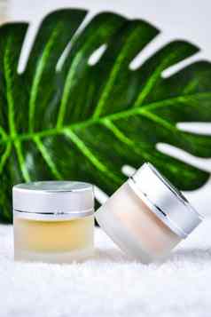 玻璃Jar奶油有机身体护理化妆品产品monstera棕榈叶子白色纺织背景水疗中心品牌模型