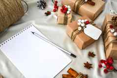 浪费圣诞节文本礼物装饰香槟彩色的丝绸背景笔记本空复制空间生态友好的包装礼物标签工艺纸板