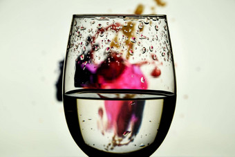 酒玻璃色彩斑斓的光绘画奢侈品飞溅喝玻璃高腿彩色的背景