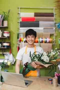 人购物出售花卉栽培技术消费主义概念关闭花店男人。包装花纸花商店
