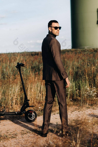 男人。业务西装绿色高尔夫球衬衫站电踏板车场蓝色的天空商人踏板车现代概念未来