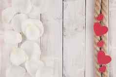 麻绳子威斯红色的心白色玫瑰花瓣白色木表格生日婚礼假期前视图复制空间