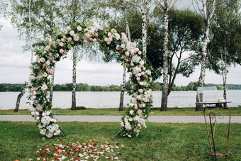 婚礼仪式街绿色草坪上装饰新鲜的花拱门仪式