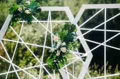 婚礼仪式街绿色草坪上装饰新鲜的花拱门仪式