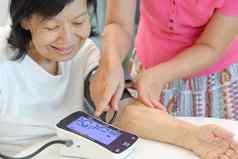 女儿检查血压力高血压上了年纪的妈妈。首页