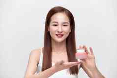 美丽的肖像年轻的亚洲女人持有展示奶油乳液产品