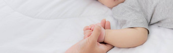 年轻的亚洲妈妈。触摸手婴儿女孩温柔的床上卧室妈妈爱新生儿护理女人表达式孩子父女儿家庭概念