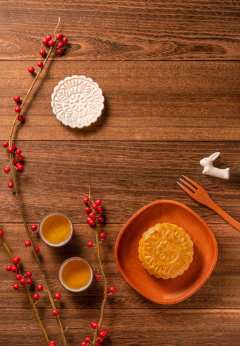 有创意的月亮蛋糕月饼表格设计中国人传统的糕点茶杯木背景中秋节日概念前视图平躺