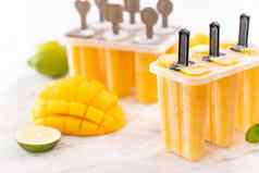 新鲜的芒果水果冰棒冰塑料塑造盒子明亮的大理石表格夏天情绪概念产品设计关闭