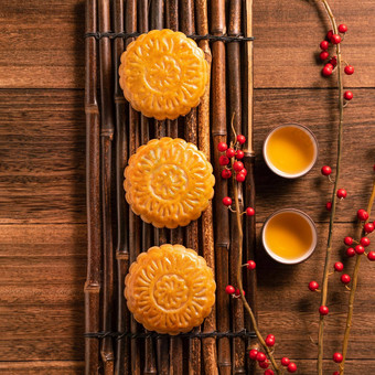 中国人传统的糕点月亮蛋糕月饼茶杯竹子服务托盘木背景中秋节日前视图平躺