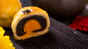 美味的烤蛋蛋黄糕点月亮蛋糕中秋节日黑色的板岩黑暗背景中国人节日食物概念关闭复制空间