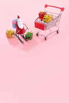 圣诞节购物概念迷你红色的商店车电车圣诞老人老人玩具礼物盒子孤立的苍白的粉红色的背景空白复制空间关闭