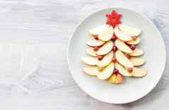 圣诞节树使切片苹果浆果大红色的木雪花明星板苹果光木背景