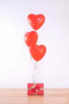 情人节一天母亲的一天生日设计概念心氦气球礼物盒子光木地板上白色墙背景关闭